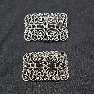 Vintage silver-tone shoe clips with a filigree design.
